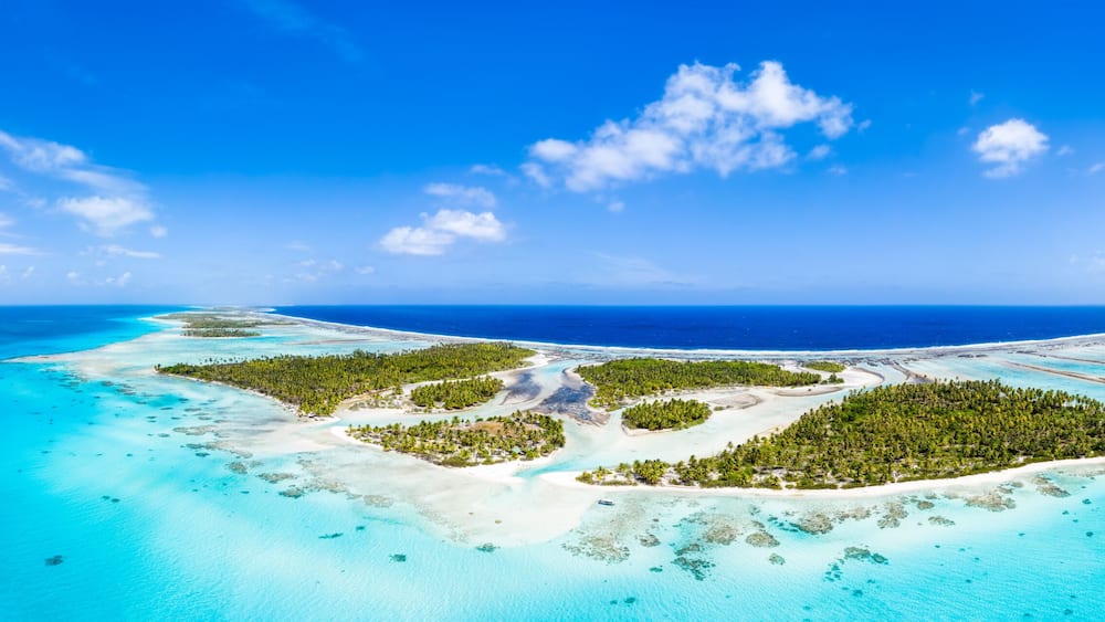 Une Ăźle tropicale aux eaux turquoise et limpides, couverte dâune vĂ©gĂ©tation luxuriante.