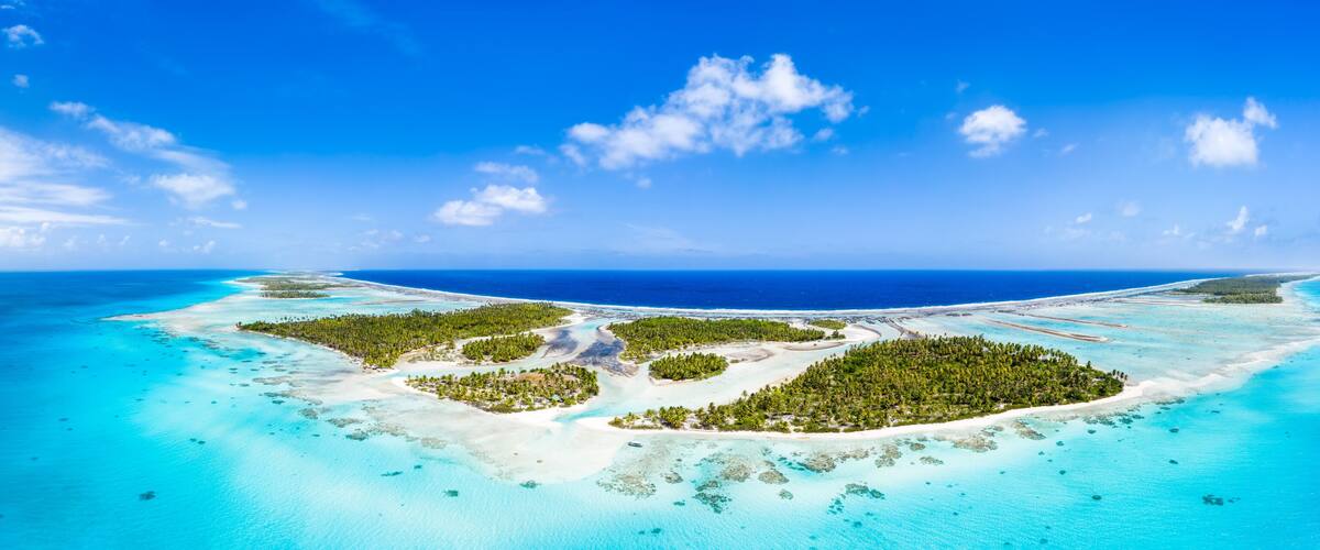 Une île tropicale aux eaux turquoise et limpides, couverte d’une végétation luxuriante.