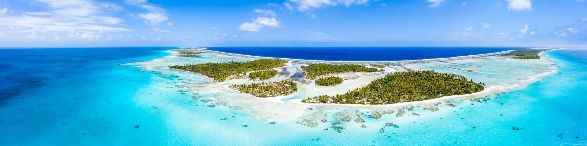 A tropical island with clear turquoise waters and dense green vegetation.