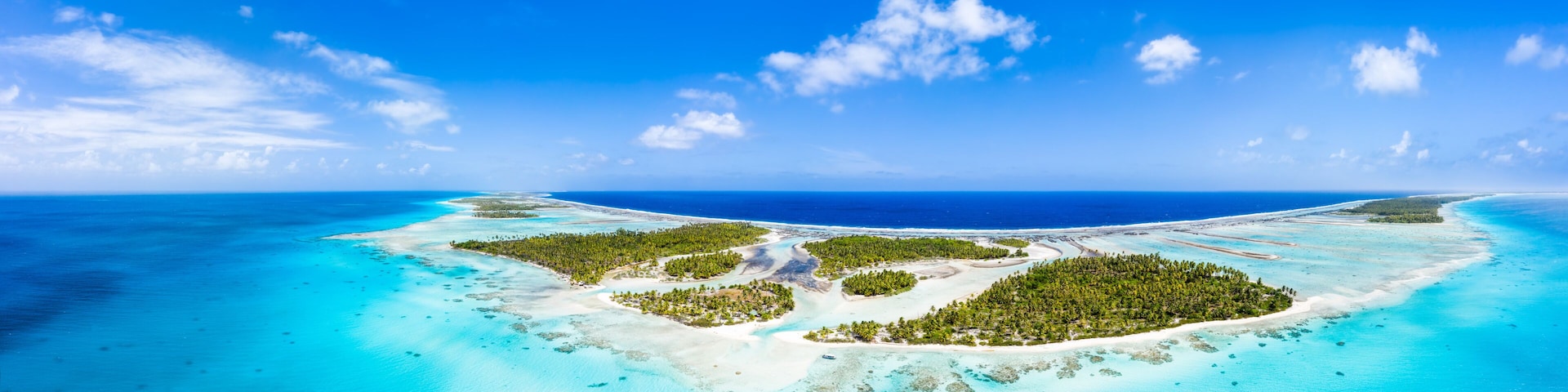 Una isla tropical con aguas turquesas cristalinas y vegetación verde exuberante.