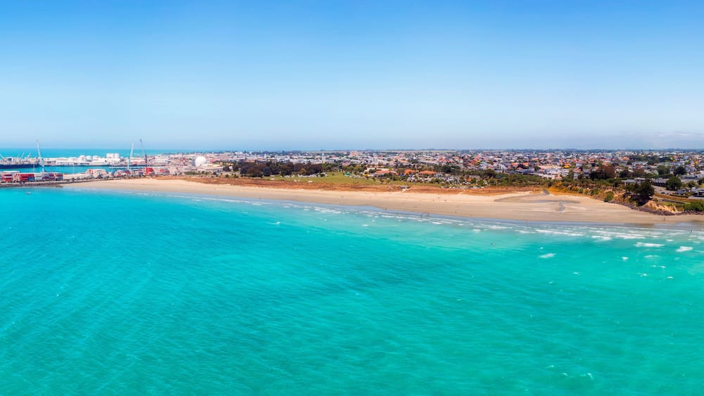 A coastal city with a beach, port, and industrial area.