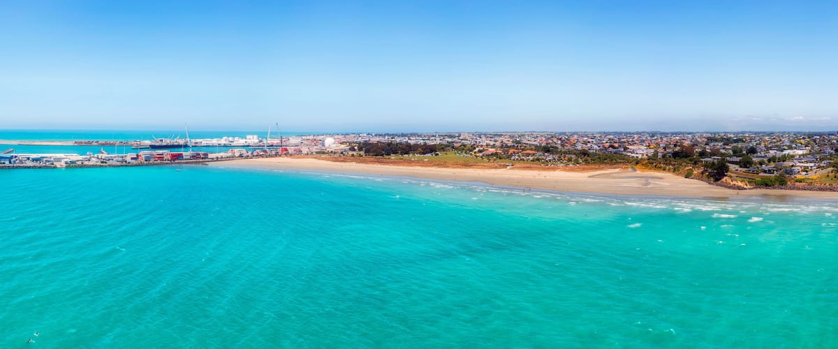 A coastal city with a beach, port, and industrial area.