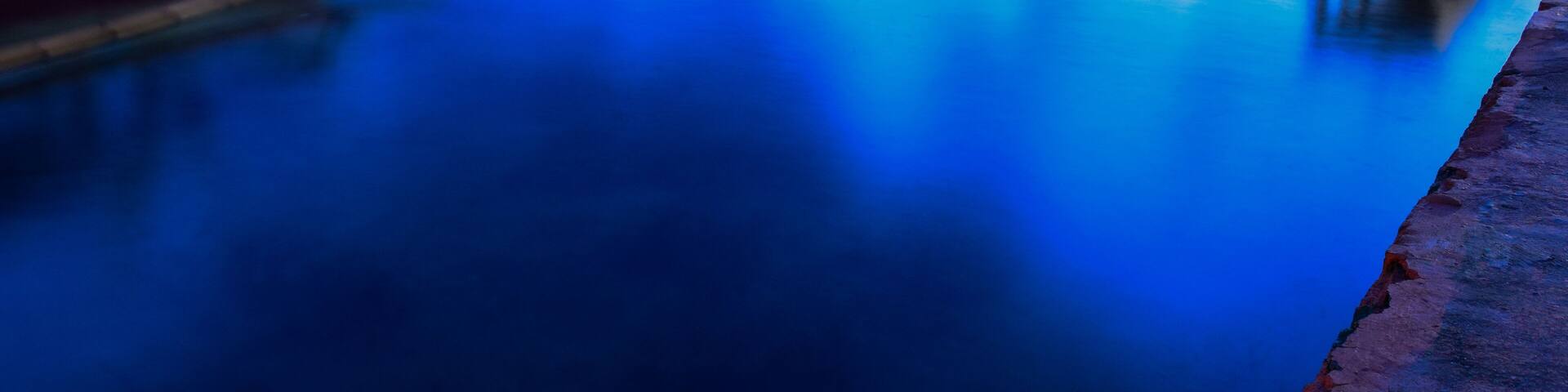 Long exposure shot of the ocean and a pier in a blue time with the old boats defocused. uploaded at Bandar Lampung. Indonesia in May 2019. Traveling concept