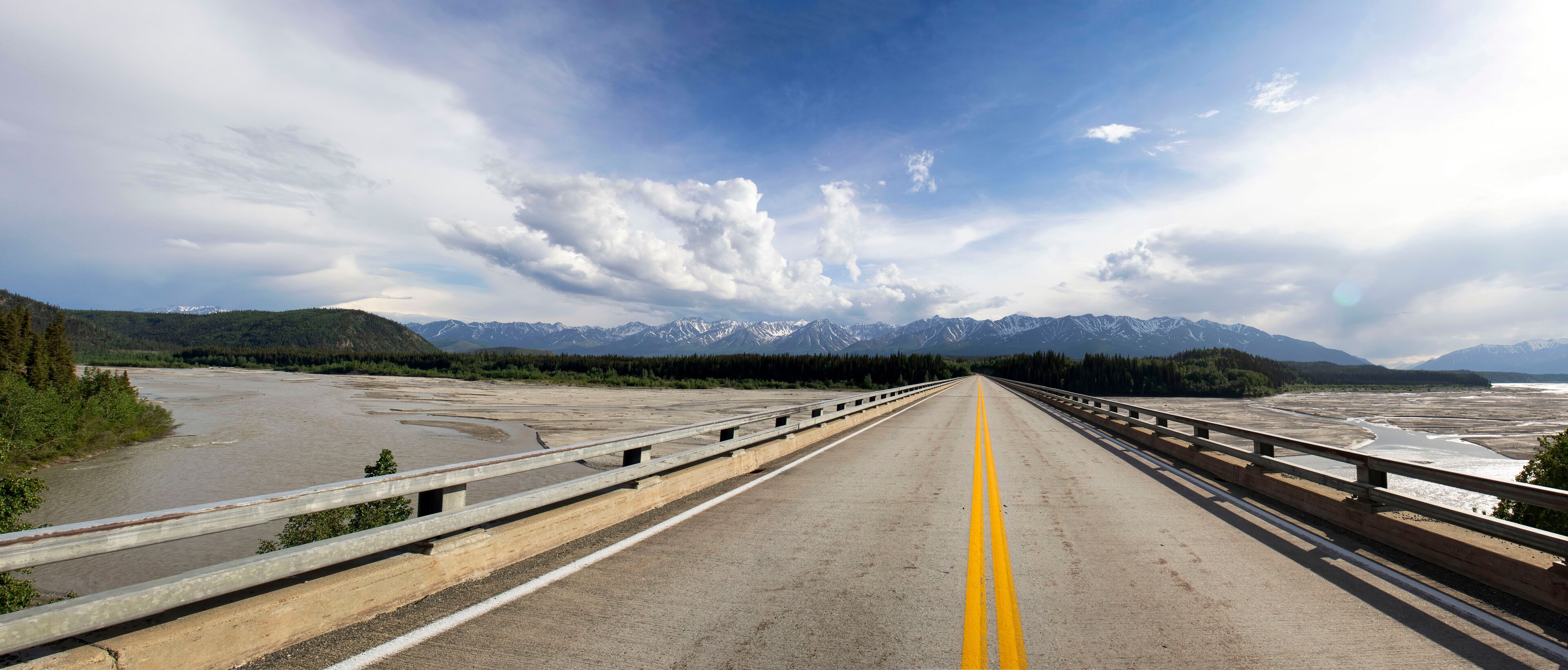 A bridge with a clear view of snow-capped mountains in the distance.