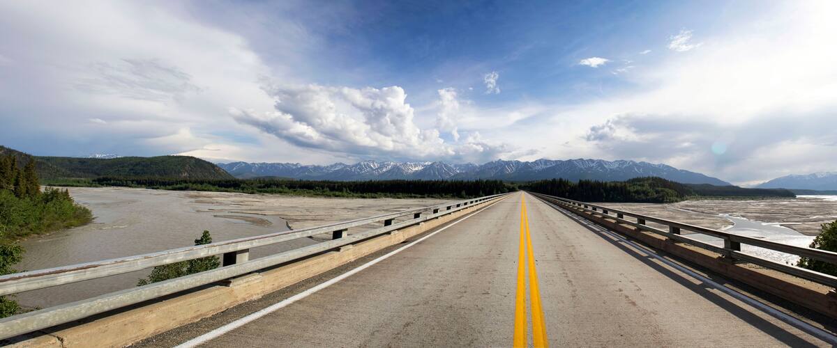 A bridge with a clear view of snow-capped mountains in the distance.