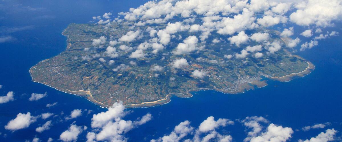 An island with scattered clouds.