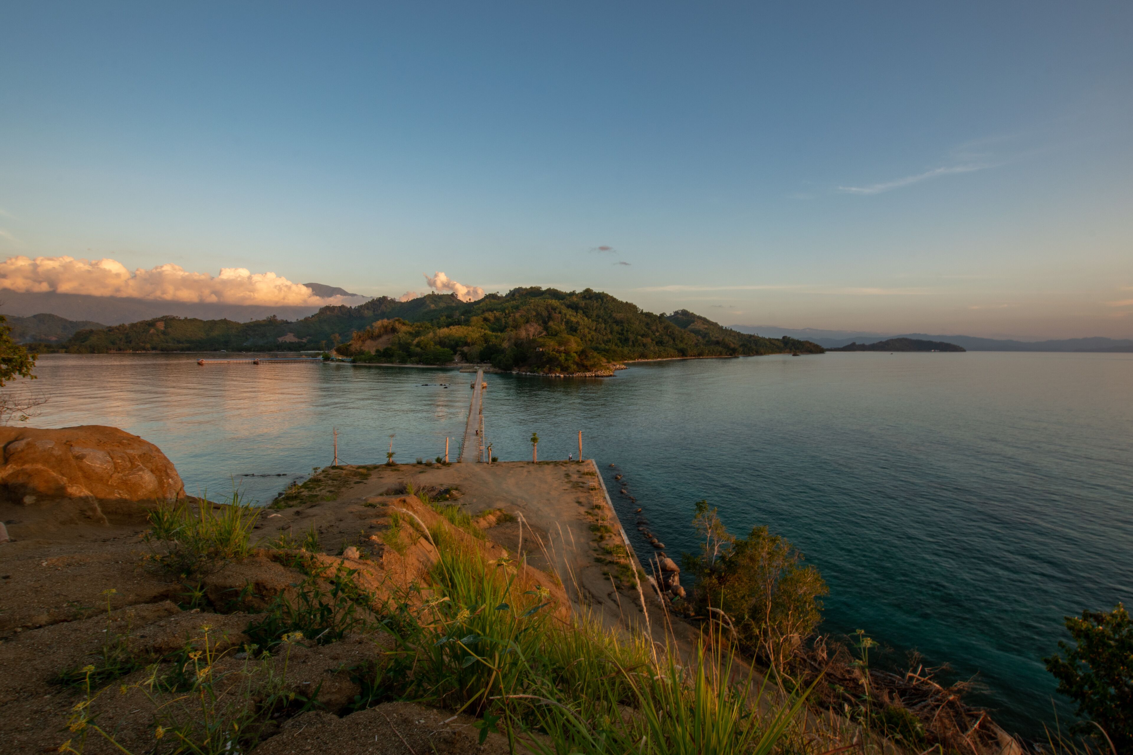 Sunset on a bridge connecting sulawesi main island and sabang tende island, tolitoli, central sulawesi, indonesia with visible rock and coral 