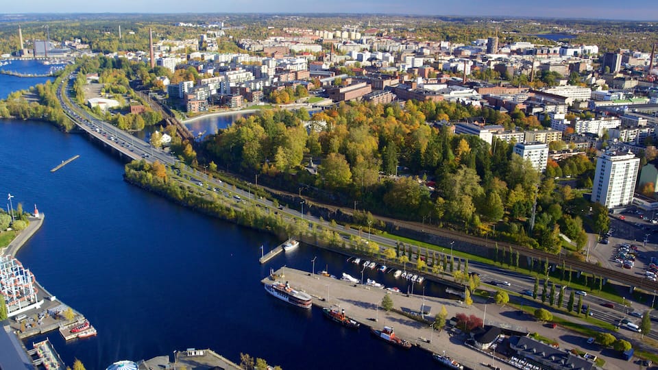 A river with a bridge, a marina, and a cityscape with buildings and trees.