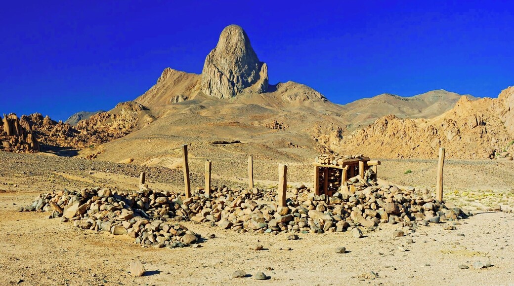 April 2011
Ilaman, Ahaggar mountains, Sahara
Ahaggar or Hoggar mountains are the rockiest and highest part of Sahara desert some 1.500 km down from Algeria coast. It is mostly highland plateau with altitude of 2.000 metres made of volcanic material ca. 2 million years old. In some places there are the remaining spikes of volcanic cones rising like the one called Ilaman with its appealing peak 2.760 m high. Water and wind eroded the surface to strangely beautiful stones of all sizes, shapes and colour shades.
The structure in front is a simple sanctuary of local Touareg people. The name Touareg means "forgotten by God" and they were titled so by the more orthodox muslims in the past. They practice the islam faith but in their way... No fancy mosques in the desert, just small structures made of stone and wood..
Make a round trip from Tamanrasset with friendly local agencies to see it!
#sahara