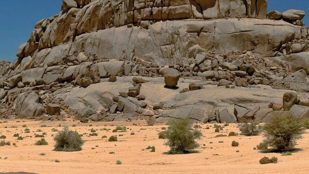 A rocky desert landscape with a prominent rock formation.