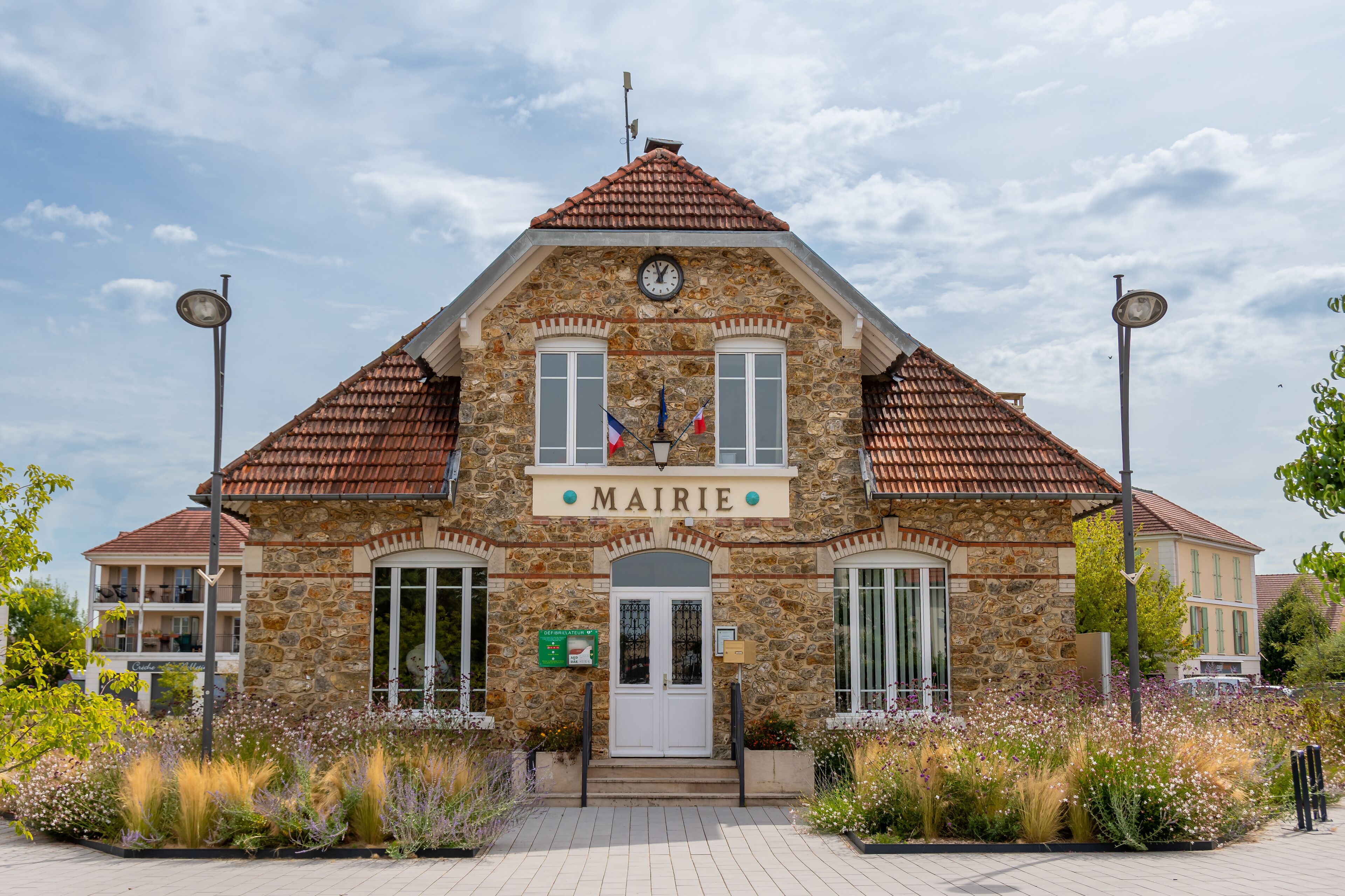 A stone building with a tiled roof and a sign reading "MAIRIE".