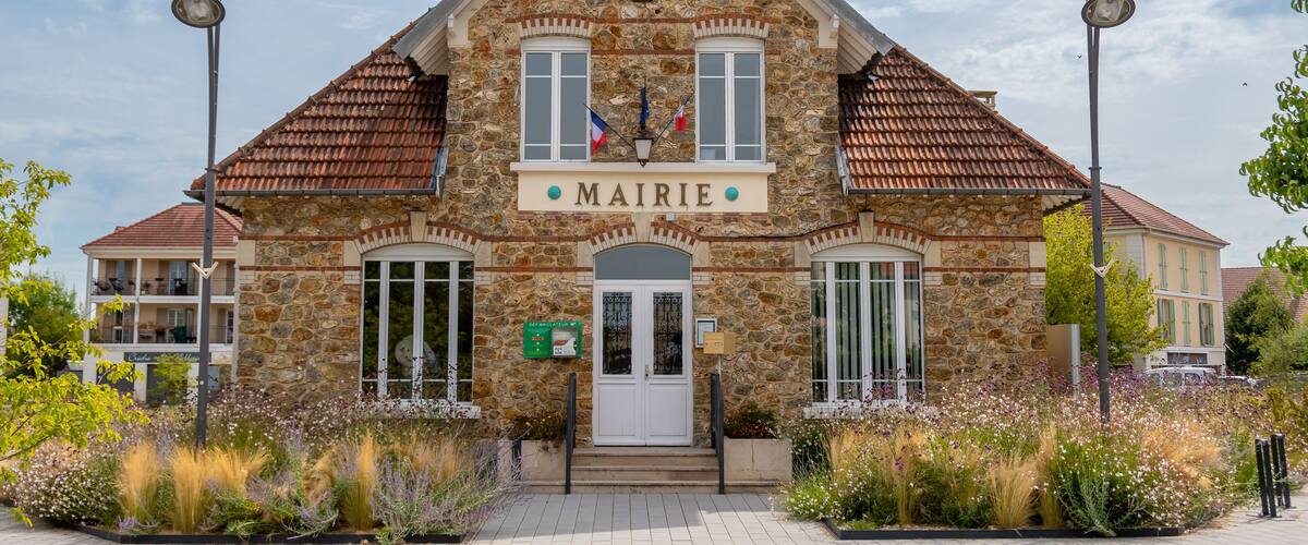 A stone building with a tiled roof and a sign reading "MAIRIE".