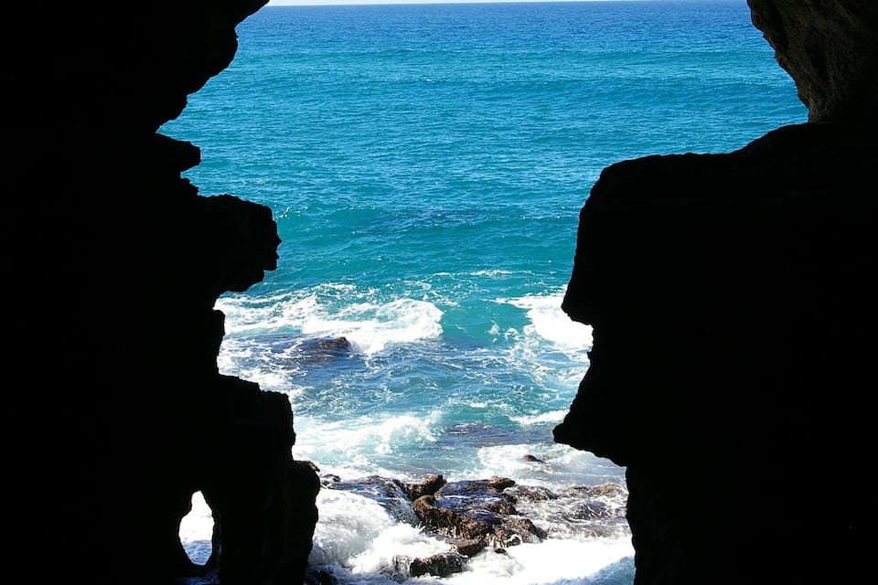 Una costa rocosa con olas rompiendo contra las rocas.