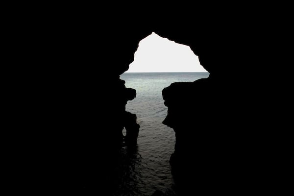 Eine Silhouette eines Höreneingangs mit Spiegelung von Himmel und Wasser.