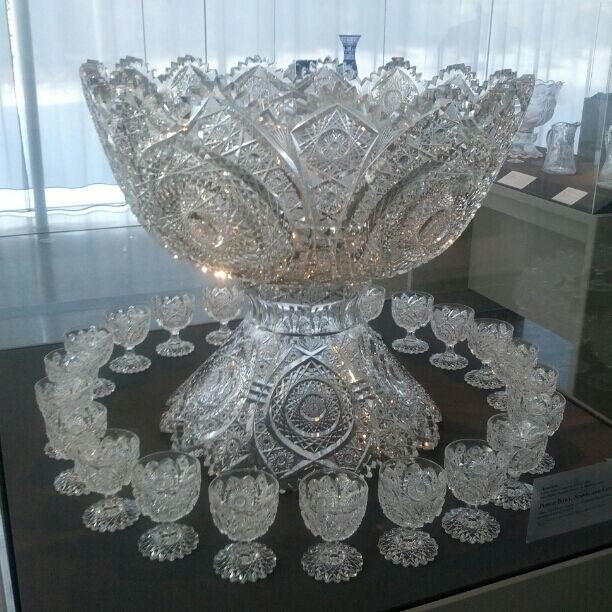 An enormous glass punch bowl, stand and glass created for the 1904 St. Louis World Fair by the Libbey Glass Company of Toledo, Ohio. The blown glass mold of the bowl weighed 143 lbs. Over 30 lbs. was cut away in the carving process.