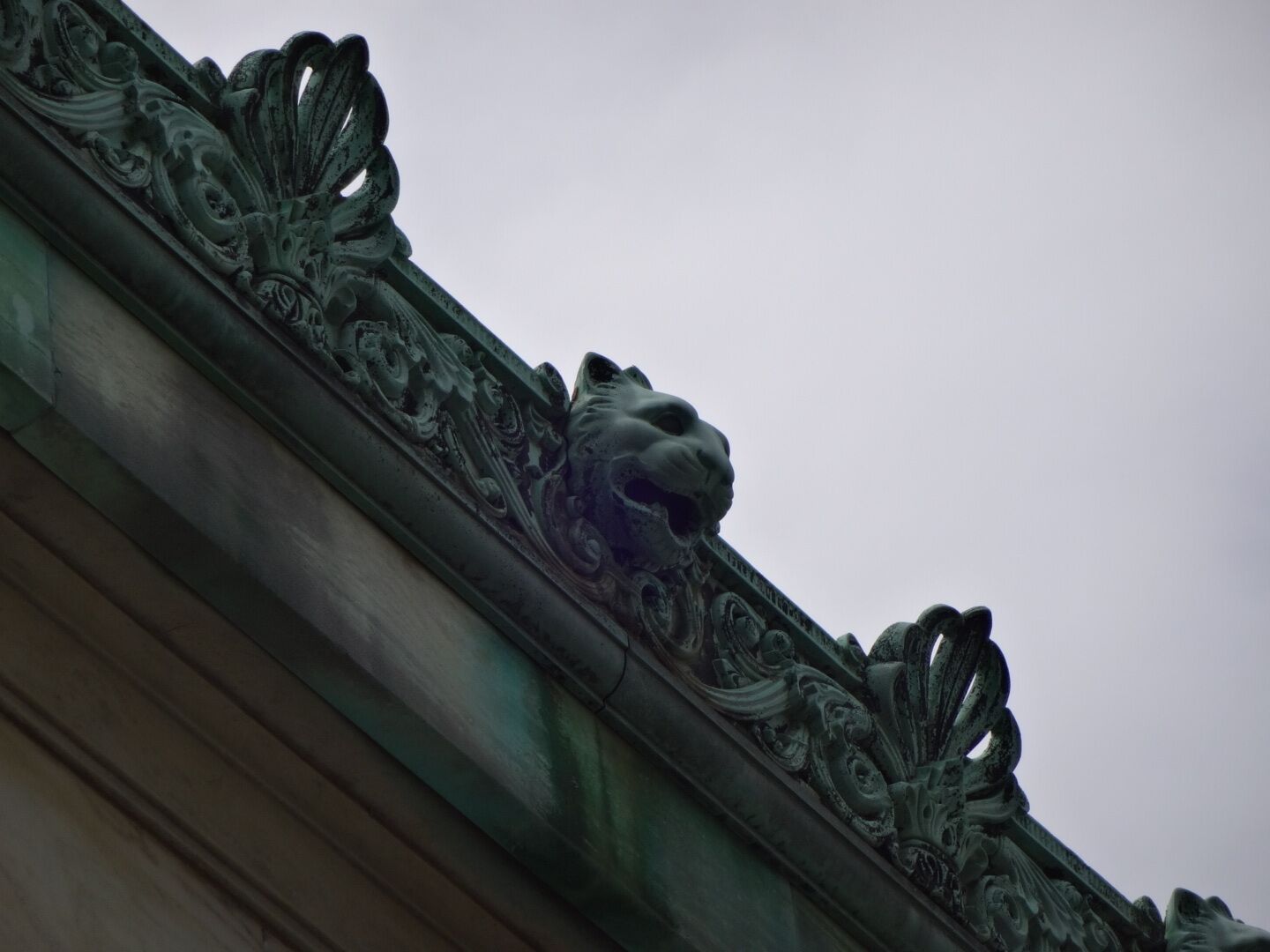 These copper lion's heads adorn the top perimeter of the main building of the Toledo Museum of Art. Opened in 1912, the Toledo Museum of Art’s Greek Ionic façade has graced the city as both landmark and legacy. The distinguished low and horizontal white marble building is articulated by a row of 16 columns, a copper roof, and a frieze of acanthus leaves. It has been renovated and expanded four times since then.