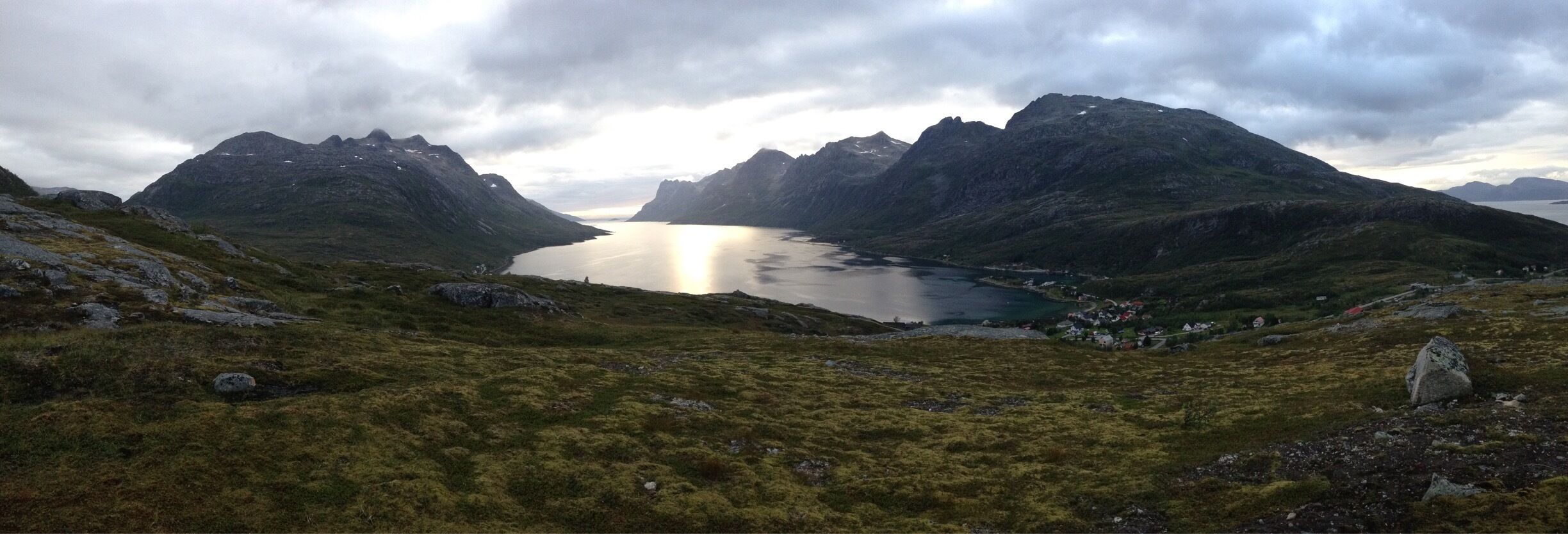 A mountainous landscape with a lake surrounded by rugged peaks.