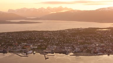 Tromso toont een klein stadje of dorpje, een zonsondergang en een meer of poel
