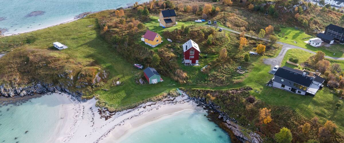 A coastal village with houses, a beach, and a rocky shoreline.