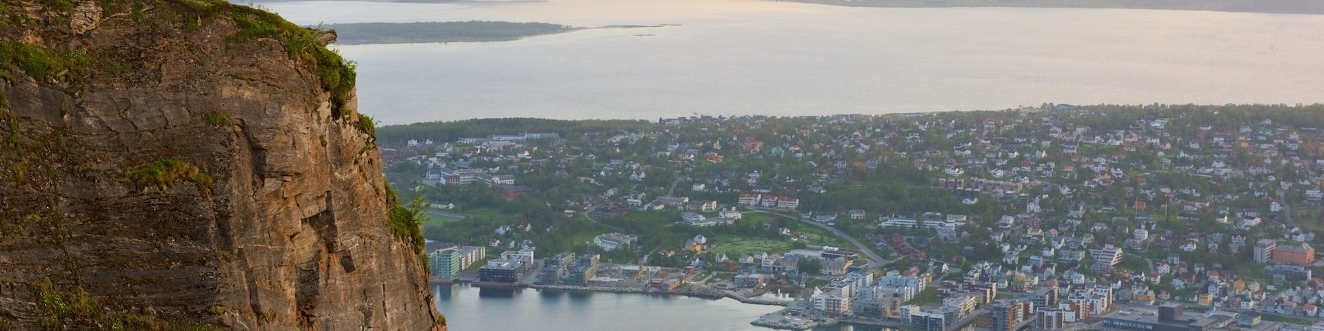 Tromso which includes a small town or village, a sunset and a lake or waterhole