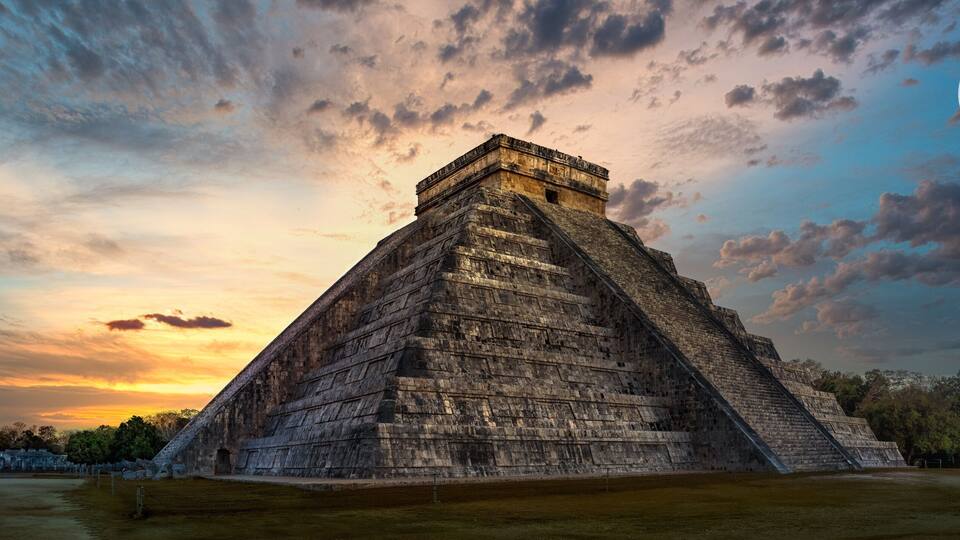 A large pyramid structure with a clear sky and a full moon in the background.