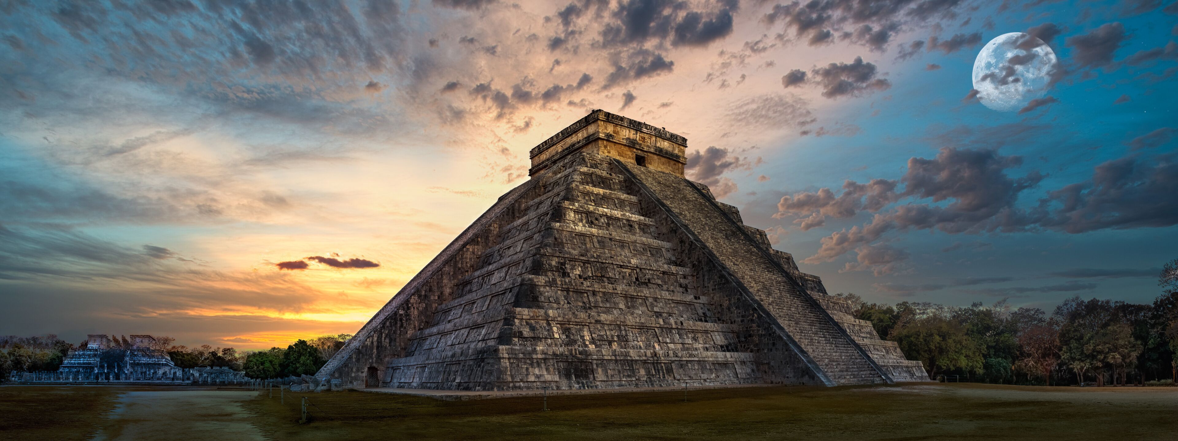 A large pyramid structure with a clear sky and a full moon in the background.
