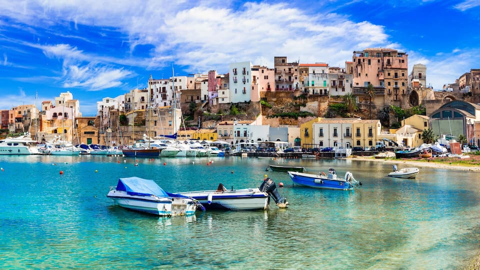 A coastal town with colorful buildings and boats docked in the harbor.
