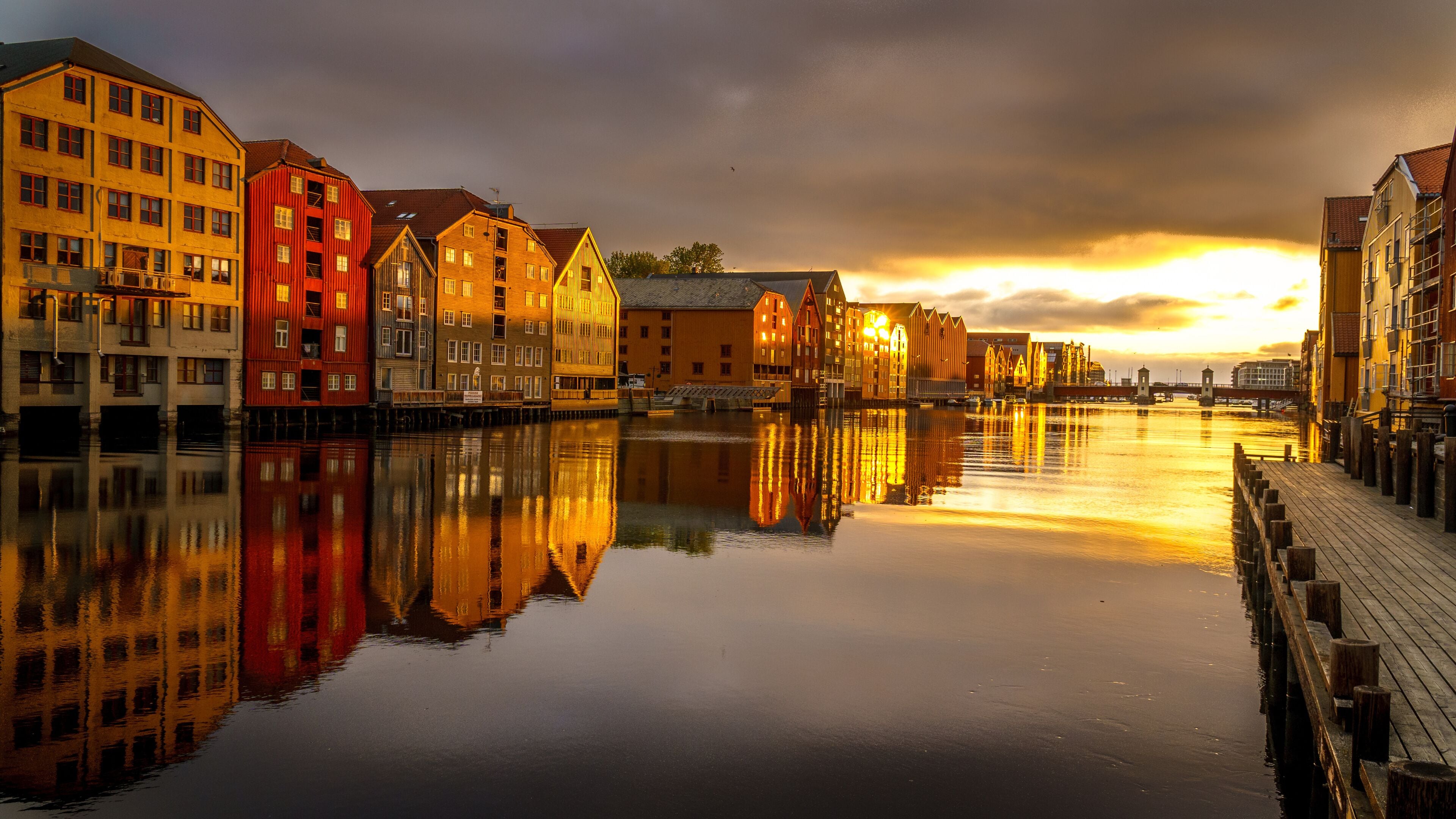Un río tranquilo que refleja edificios coloridos al atardecer.