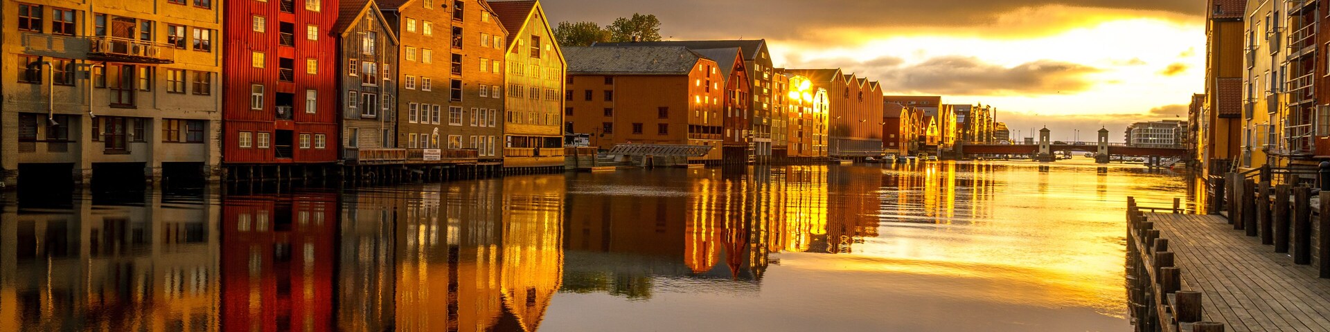 Un río tranquilo que refleja edificios coloridos al atardecer.