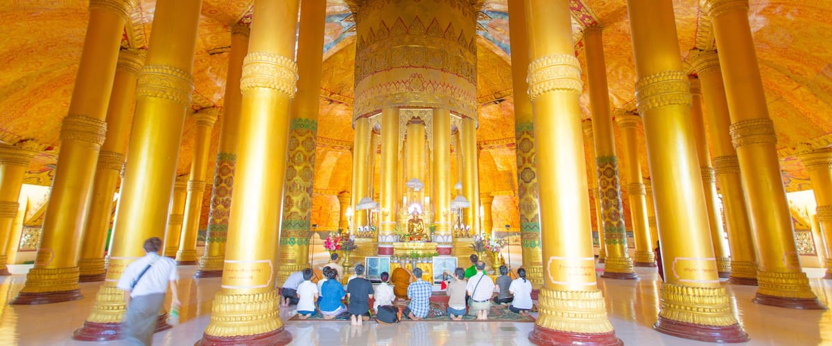 A temple interior with golden columns and intricate ceiling designs.