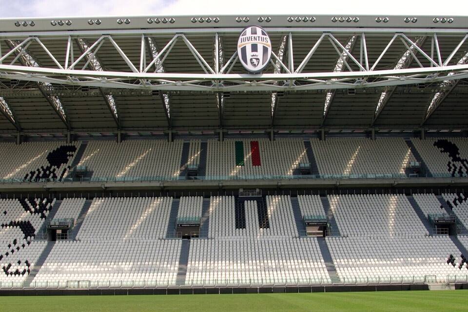 An empty stadium with a roof structure and seating sections.