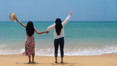 Two girls holding hands of each other, enjoying beautiful view of ocean. Kerala, Poovar, Island, horizon, Goa, India, Maldives, friends, couple, freedom, life, waves, turquoise, play, sunny, beach.
