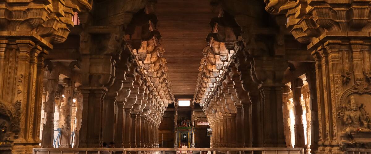 An ornate temple interior with intricate carvings and a central shrine.