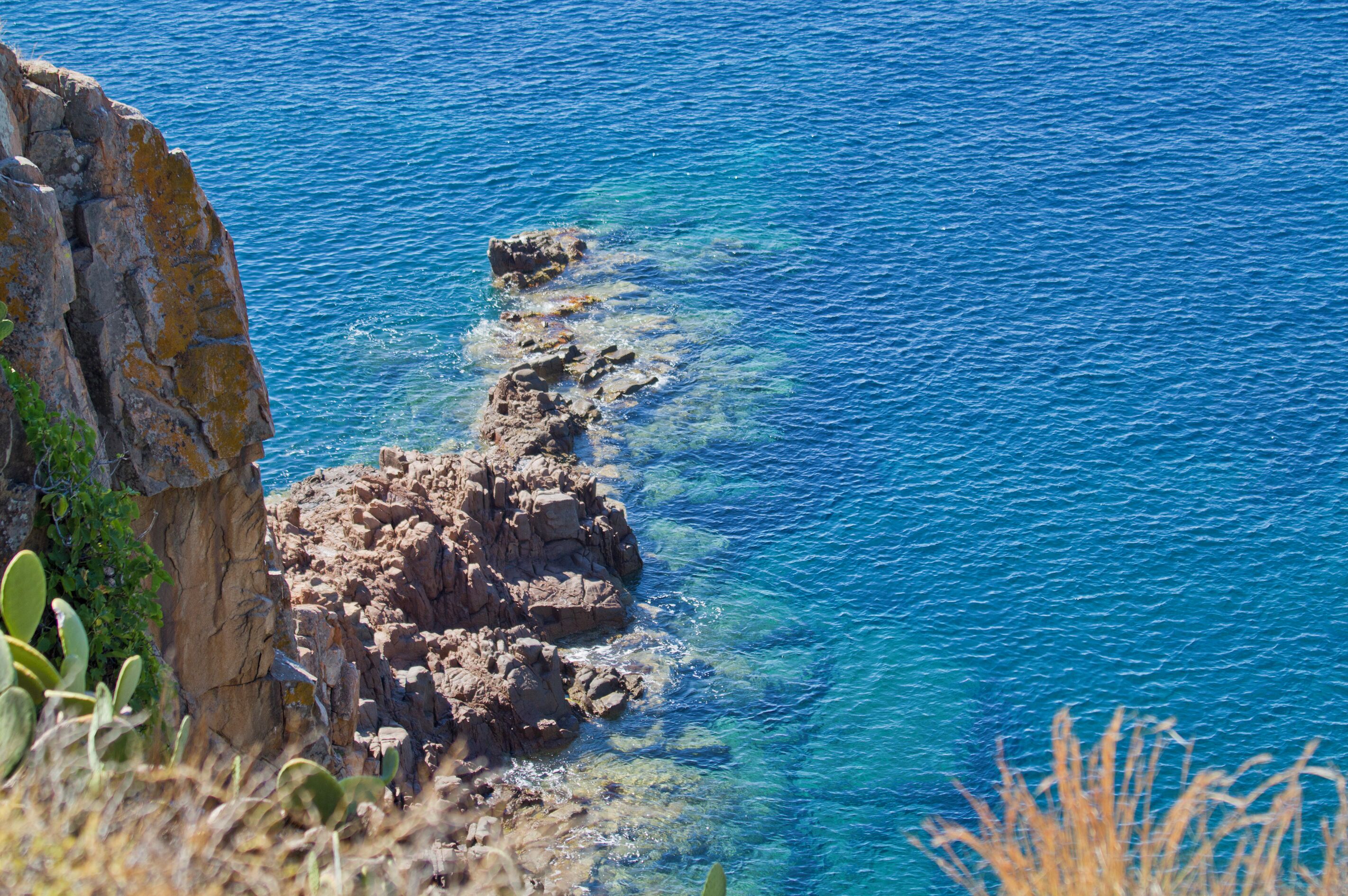 A rocky coastline with clear blue water.