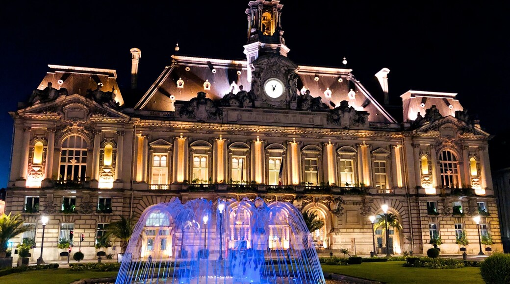 The Tours Town Hall was built between 1896 and 1904 by the Tours architect Victor Laloux on the right-hand side of rue Nationale, and was a monumental building, disproportionately large compared to Place Jean-JaurĂšs and the Palais de Justice, designed to reflect the republican virtues and municipal authority. The town hall and the Jean JaurĂšs square evoke a Parisian layout.
On the façade, there are four Atlanteans by François Sicard; to the left and right of the clock, two caryatids (Le Jour et la Nuit) are by Ămile Joseph Nestor Carlier (1849-1927). Two elongated characters represent the Loire (left) and the Cher. They are by Jean-Antoine Injalbert. The two wings are decorated: to the west, the Courage and Force of Jean-Baptiste Hughes, and to the east, Education and Vigilance, of Alphonse Cordonnier.
Its roof served as a model for the restoration of Montreal City Hall following its fire in 1922.