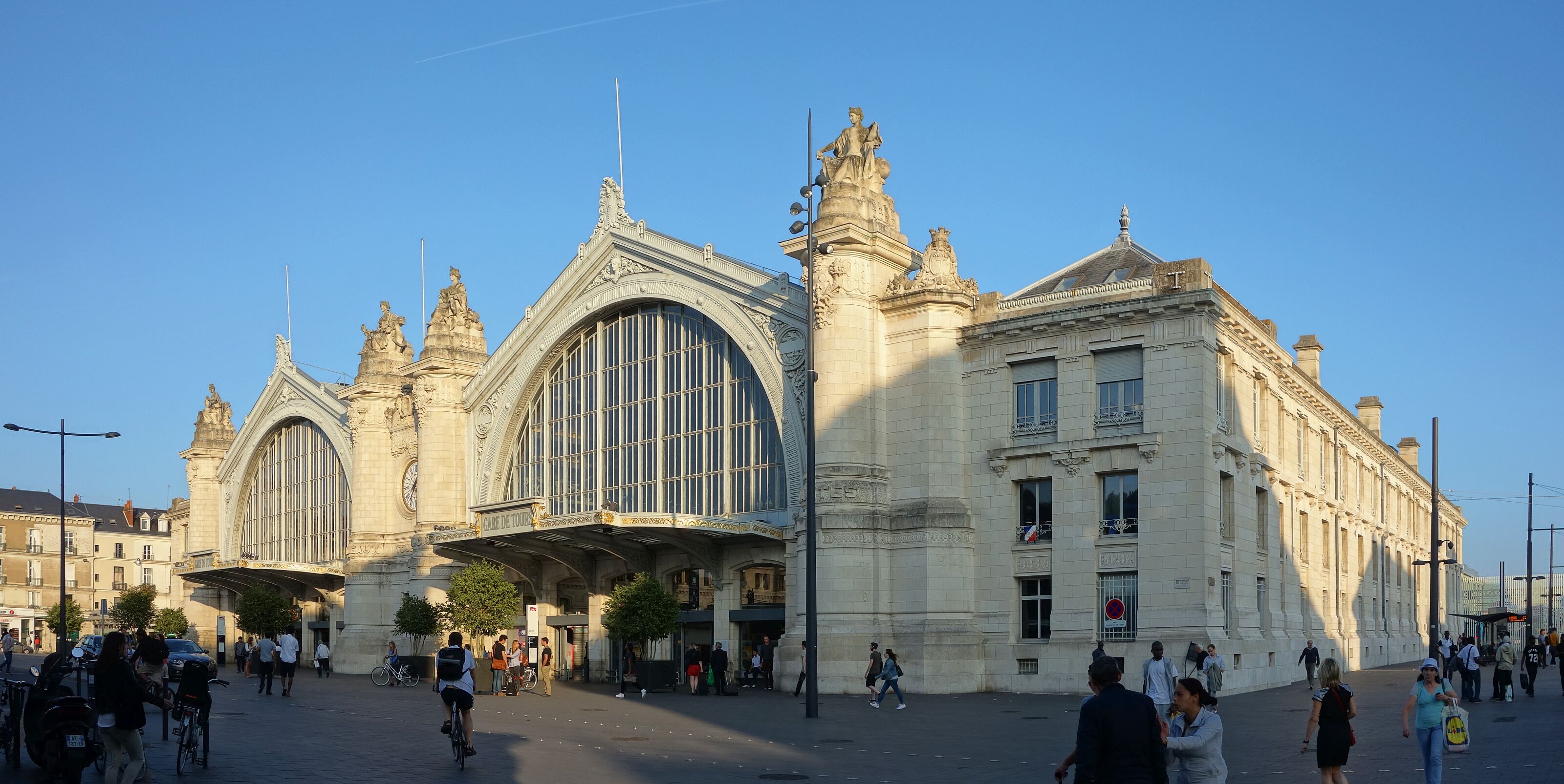 A grand historic train station with ornate architecture and large arched windows.