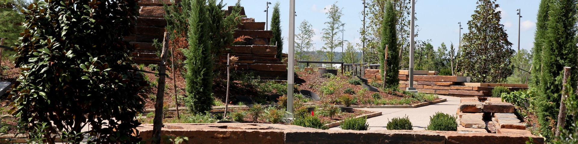 A landscaped garden with stone steps, various shrubs, and trees.