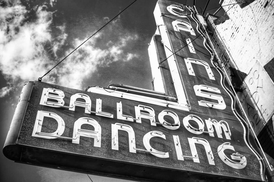 A sign for a building with a large 'L' and the words "BALLROOM DANCING" on it.