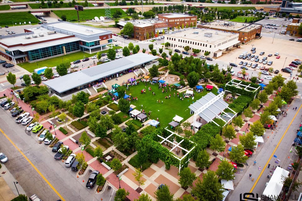 An aerial view of a university campus with green lawns, buildings, and a parking lot.