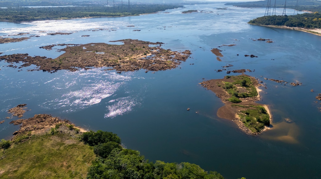 Un río con islas rocosas y el horizonte de una ciudad a lo lejos.