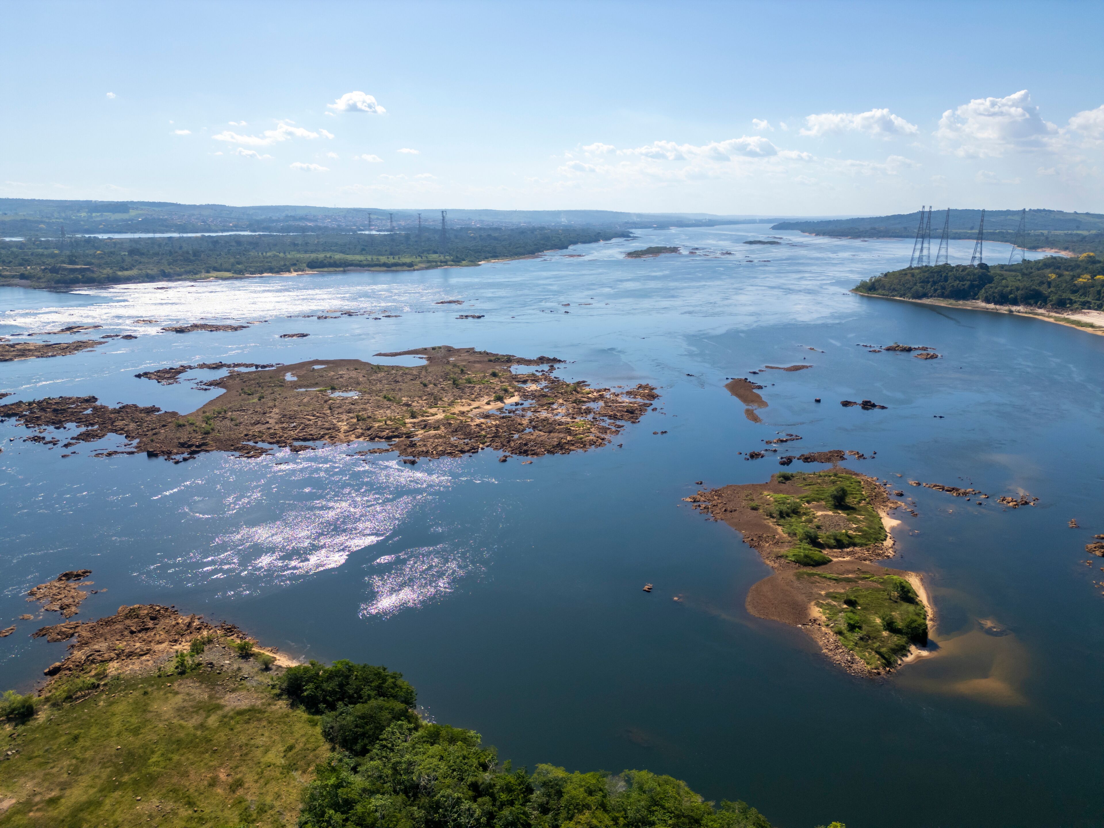 A river with rocky islands and a distant city skyline.