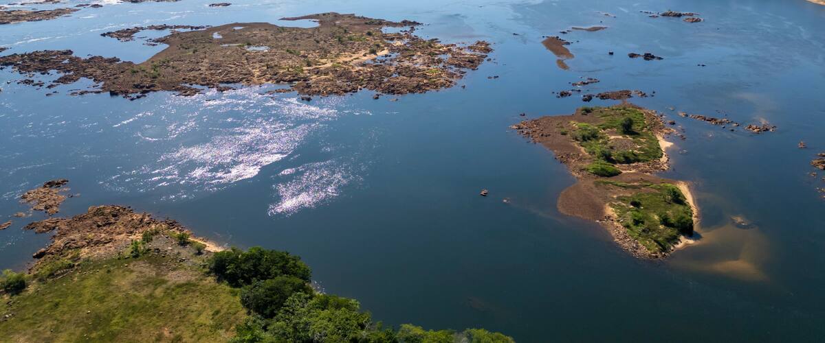 A river with rocky islands and a distant city skyline.