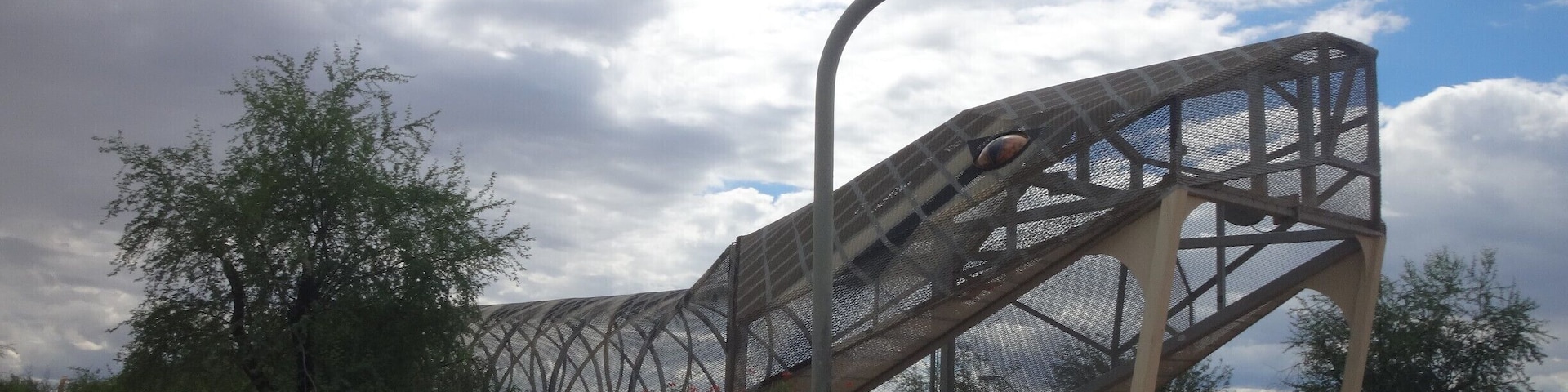 Unique pedestrian bridge. It continues on to the other side of the road, where its rattle rises up out of the sidewalk.