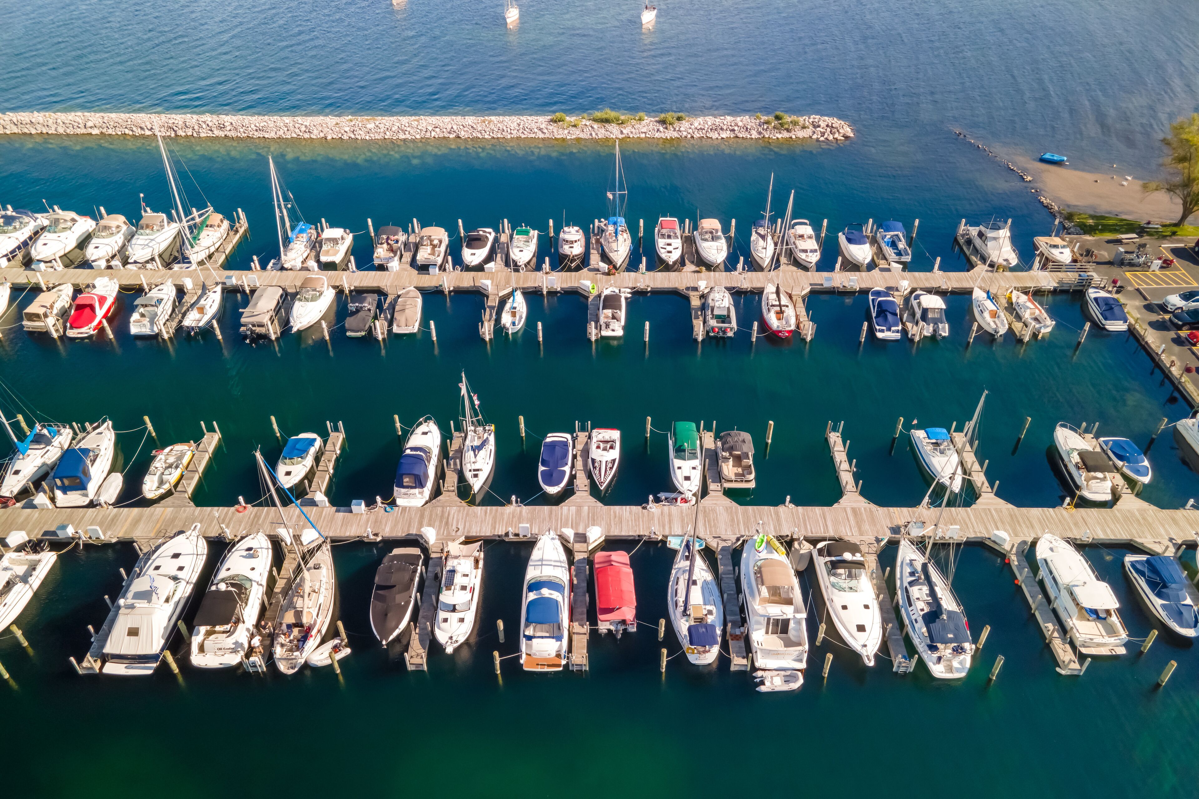 An aerial view of a marina with numerous boats docked at wooden piers.