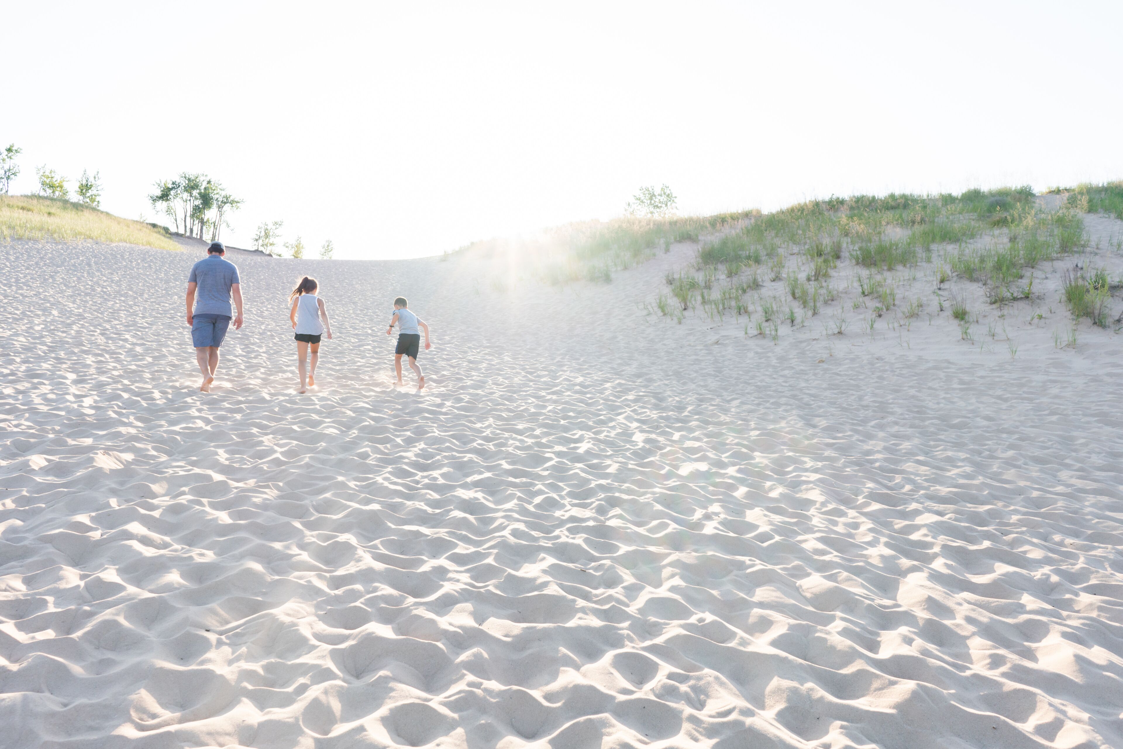 Family climbing Sleeping Bear Dunes at Sunset