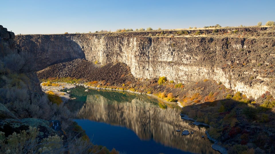 A canyon with a river reflecting the cliffs.
