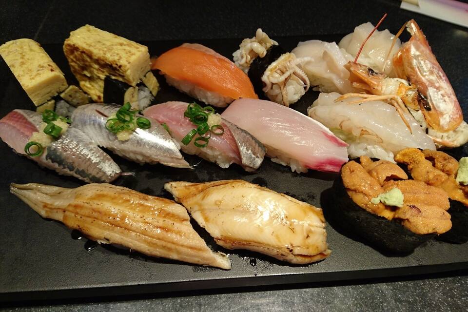 Diversitat de sushi sobre un plat negre.