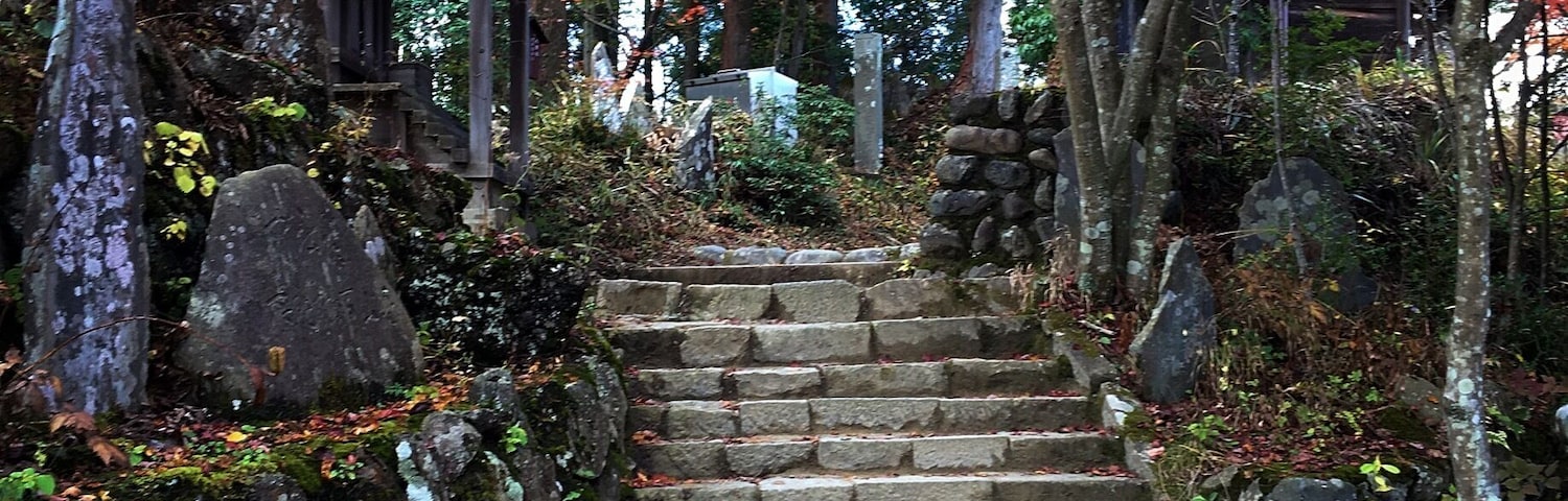 A stone staircase surrounded by autumn foliage and traditional architecture.
