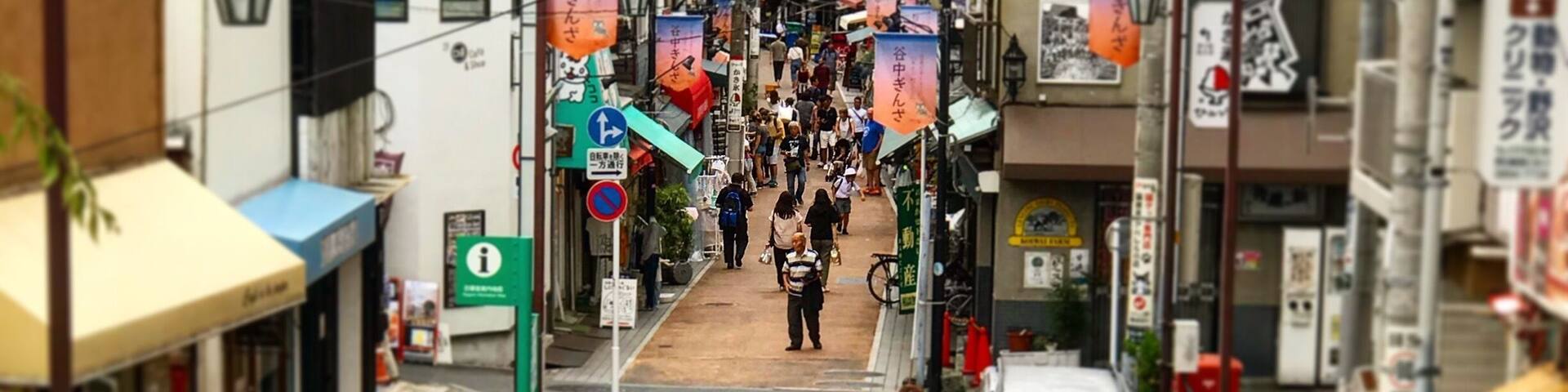 A busy urban street with pedestrians, bicycles, and a white van.