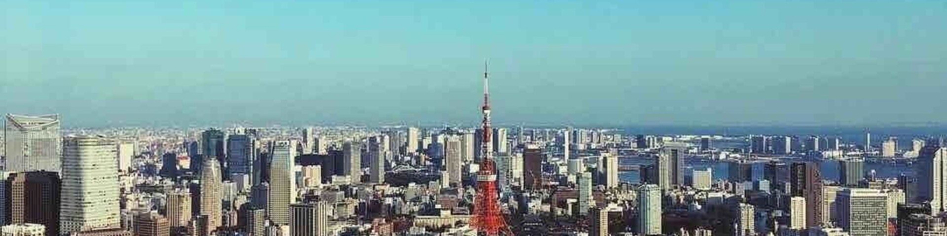A cityscape with a prominent red tower in the center, surrounded by dense urban buildings.